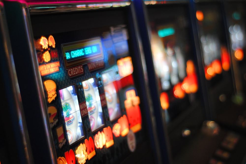 Tampilan close-up mesin slot dengan lampu dan simbol permainan